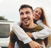 A woman gets a piggyback ride from her partner.  